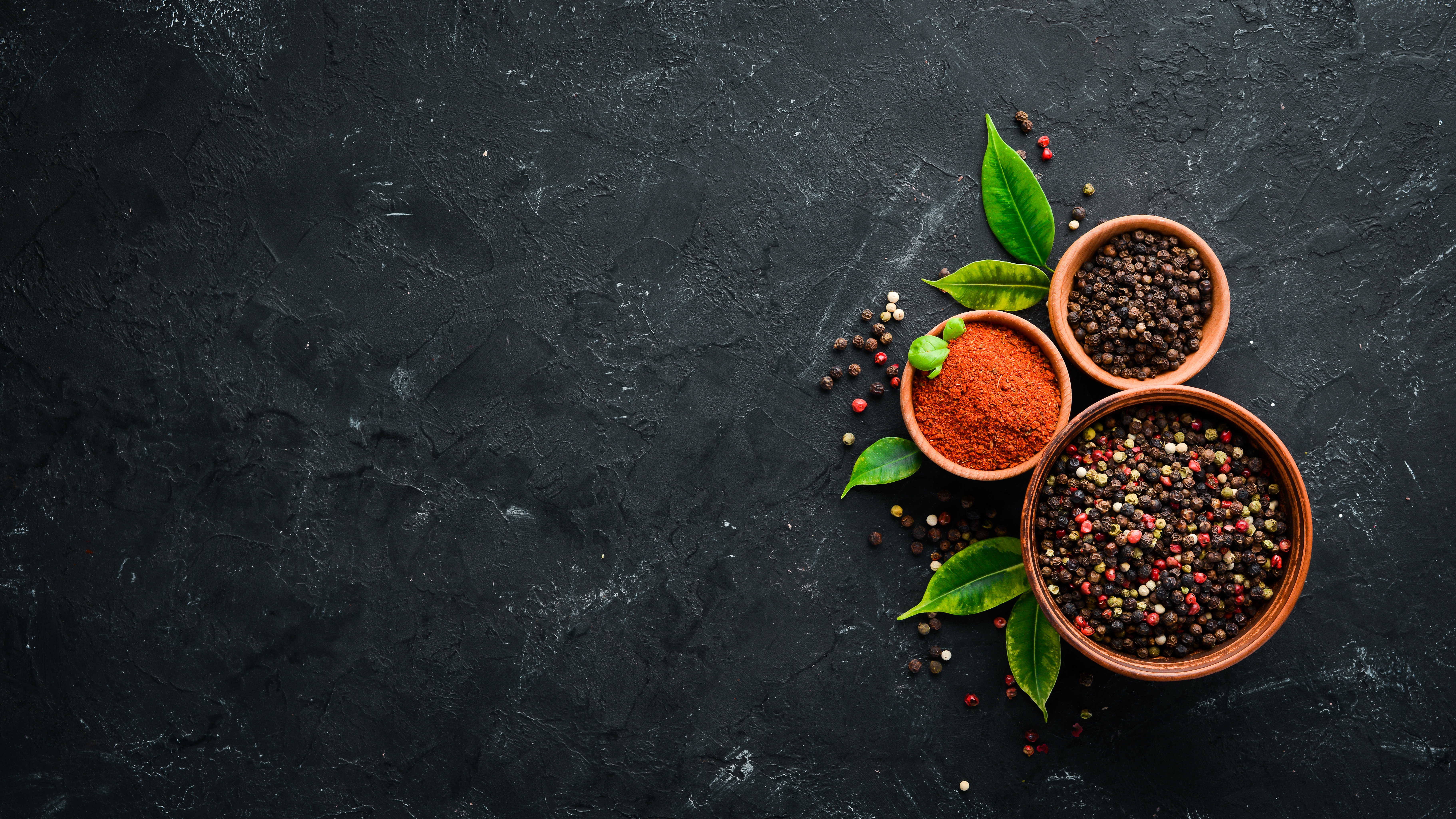 A set of peppers. Black pepper, colored pepper, ground pepper, dried chili pepper. Top view. On a black background. free space for your text.